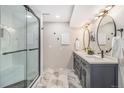 Bathroom featuring a glass-enclosed shower and double vanity with modern lighting and stylish finishes at 6731 Devinney St, Arvada, CO 80004