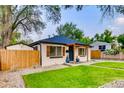 Inviting home with a well-manicured lawn, a wooden fence, fresh landscaping, and a charming pergola covered entry at 150 S Osceola St, Denver, CO 80219