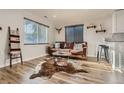 Cozy living room featuring hardwood floors, a leather sofa, and bright windows with stylish blinds at 150 S Osceola St, Denver, CO 80219