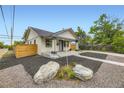 Charming bungalow with new landscaping, painted brick, inviting porch, and contemporary design elements at 1694 Xanthia St, Denver, CO 80220