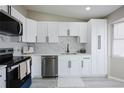 A beautifully renovated kitchen with white cabinets, stainless steel appliances, and a modern backsplash at 1075 S Garrison St # 201, Lakewood, CO 80226