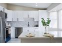 Renovated kitchen boasts white cabinets, quartz counters, and stainless steel appliances at 1075 S Garrison St # 201, Lakewood, CO 80226
