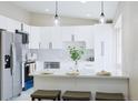 Bright, modern kitchen with white cabinets, stainless steel appliances, and an island with bar seating at 1075 S Garrison St # 201, Lakewood, CO 80226
