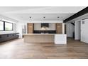 Bright open kitchen features stainless appliances, large island, and sleek modern lighting at 5031 Moss Pl, Golden, CO 80403