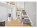 Bright foyer with hardwood floors, a staircase leading to the second floor, and a view of the dining area at 11035 W Grand Pl, Littleton, CO 80127