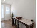 Bright entryway with a marble-top console table and hardwood floors at 1171 E Hopkins Dr, Elizabeth, CO 80107