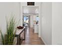 Hallway with hardwood floors offering views into the kitchen and living areas at 1171 E Hopkins Dr, Elizabeth, CO 80107