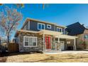 Two-story craftsman style home with gray siding, stone accents and a red door at 3050 S Ash St, Denver, CO 80222