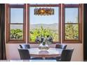 Cozy dining room with mountain views, stylish lighting, and seating for four around a marble table at 2587 S Harlan Ct, Lakewood, CO 80227