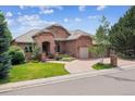 Charming brick home with a well-maintained lawn, mature trees, and an inviting front entrance at 2587 S Harlan Ct, Lakewood, CO 80227