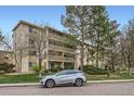 Apartment building with covered patios, lush landscaping, and a silver SUV parked nearby at 3144 S Wheeling Way # 401, Aurora, CO 80014