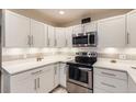 Bright kitchen features white cabinetry, stainless steel appliances, and modern countertops at 3144 S Wheeling Way # 401, Aurora, CO 80014