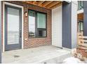 Charming porch with brick accents, modern lighting, and a sleek door creates an inviting entryway at 3550 Uinta St # 6, Denver, CO 80238