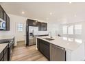 Bright modern kitchen with white countertops, dark cabinets, stainless steel appliances, and center island sink at 2190 S Haleyville Way, Aurora, CO 80018