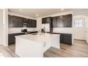 Well-lit modern kitchen with white countertops, dark cabinets, stainless steel appliances and spacious island at 2190 S Haleyville Way, Aurora, CO 80018