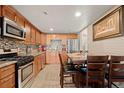 Well-lit kitchen with stainless appliances, granite counters, and adjacent dining area at 7511 Locust St, Commerce City, CO 80022