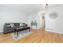 Hardwood floor living room with gray couch and view of kitchen at 3428 S Sherman St, Englewood, CO 80113