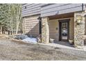Home's charming front entrance featuring stone pillar accents, a glass front door, and a bear statue at 2971 Fall River Rd, Idaho Springs, CO 80452