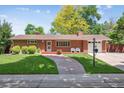 Charming red brick home with a manicured lawn and a stone walkway to the front door at 1040 Zang St, Golden, CO 80401