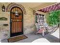 Cozy front porch with a wooden door, brick accents, and seating for relaxing outdoors at 583 S York St, Denver, CO 80209