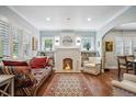 Bright living room featuring hardwood floors, a decorative fireplace, and large windows with custom shutters at 583 S York St, Denver, CO 80209