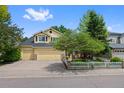 Charming yellow two-story home with a well-manicured lawn and a three car attached garage at 7638 S Hudson Way, Centennial, CO 80122
