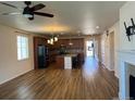 Open-concept living space with wood-look flooring leading to an island kitchen with barstool seating at 22822 E Union Cir, Aurora, CO 80015