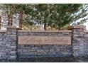 Stone monument sign reading 'Highlands at Westbury' surrounded by mature trees and manicured landscape at 11277 Osage Cir # E, Westminster, CO 80234