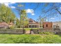 Spacious backyard with mature trees and a low brick wall surrounding the property at 6285 W 35Th Ave, Wheat Ridge, CO 80033