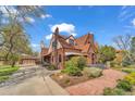 Brick home with driveway leading to detached garage, complemented by mature landscaping and a red brick walkway at 6285 W 35Th Ave, Wheat Ridge, CO 80033