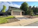 Two-story home with green siding, brick accents, and a well-manicured lawn at 9852 W 76Th Ave, Arvada, CO 80005