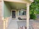 Close-up of the home's front door, showing the entrance and surrounding landscape at 9852 W 76Th Ave, Arvada, CO 80005
