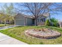Landscaped front yard features lush green grass and decorative rocks, adding a touch of nature to the home's exterior at 5335 S Lisbon Way, Centennial, CO 80015