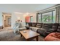 Cozy living room featuring a large window, a comfortable brown leather sectional and view of an adjacent room at 4465 Cody St, Wheat Ridge, CO 80033