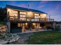 Rear of the house, highlighting the deck, lower level patio with seating, grill, hot tub, and outdoor space at 1559 Lisbon Dr, Parker, CO 80138