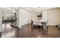Dining room with dark hardwood floors, modern light fixture, and open view to the living room at 19471 W 59Th Ave, Golden, CO 80403