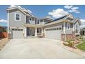 Gray two-story home featuring a two-car garage, complemented by well-kept landscaping and stone accents at 19471 W 59Th Ave, Golden, CO 80403