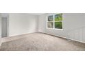 Bright, carpeted bedroom with a large window offering a pleasant view; freshly painted in a neutral color at 3246 S Nucla St, Aurora, CO 80013