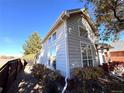 Side view of the home featuring ample windows for great light, brick details, and mature landscaping at 10311 Adams Pl, Thornton, CO 80229