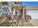Close-up of a home's brick-accented front porch, showcasing the entrance with sidelights at 10311 Adams Pl, Thornton, CO 80229