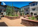 Beautiful courtyard with planters, stone benches, and manicured landscaping between residential buildings at 2800 Aurora Ave # 121, Boulder, CO 80303