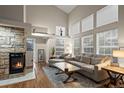 Spacious living room with a stone fireplace, vaulted ceiling, and abundant natural light at 6848 Zenobia St # 9, Westminster, CO 80030