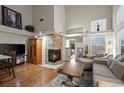 Bright living room featuring a stone fireplace, vaulted ceiling, and hardwood floors at 6848 Zenobia St # 9, Westminster, CO 80030