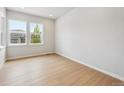 Bright bedroom featuring hardwood floors and natural light from the large windows at 1400 Colony Dr, Erie, CO 80026