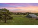 Picturesque backyard with a lush green field and outbuilding at 19855 Draco Dr, Monument, CO 80132