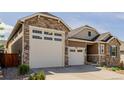 Charming home with a two-car garage, stone accents, and well-maintained landscaping at 3059 Morningbird Ln, Castle Rock, CO 80109