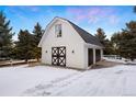 Charming barn with black trim, offering both rustic charm and modern functionality with two garage doors at 7883 Fox Creek Trl, Franktown, CO 80116