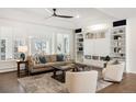 Bright living room with a built-in bookcase, plush furniture, and natural light with a view to the balcony at 7883 Fox Creek Trl, Franktown, CO 80116