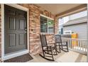 Inviting covered front porch with rocking chairs, perfect for relaxing and enjoying the neighborhood at 7472 S Memphis St, Aurora, CO 80016