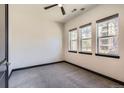 Bright bedroom with neutral carpet, three large windows, and dark trim at 7837 Inverness Blvd, Englewood, CO 80112